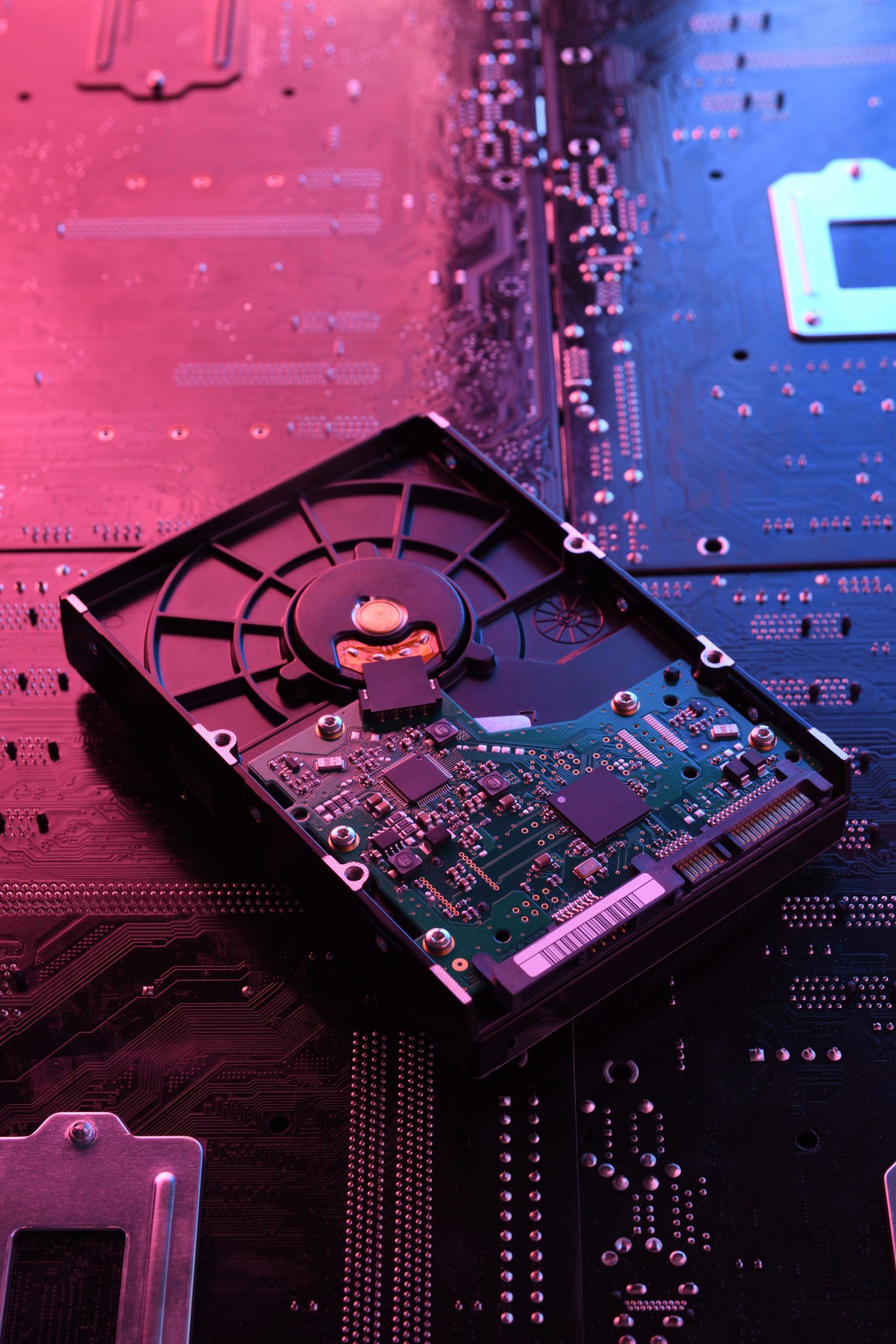 computer-hard-disk-drives-hdd-ssd-circuit-board-motherboard-close-up-with-red-blue-lighting_150455-1723